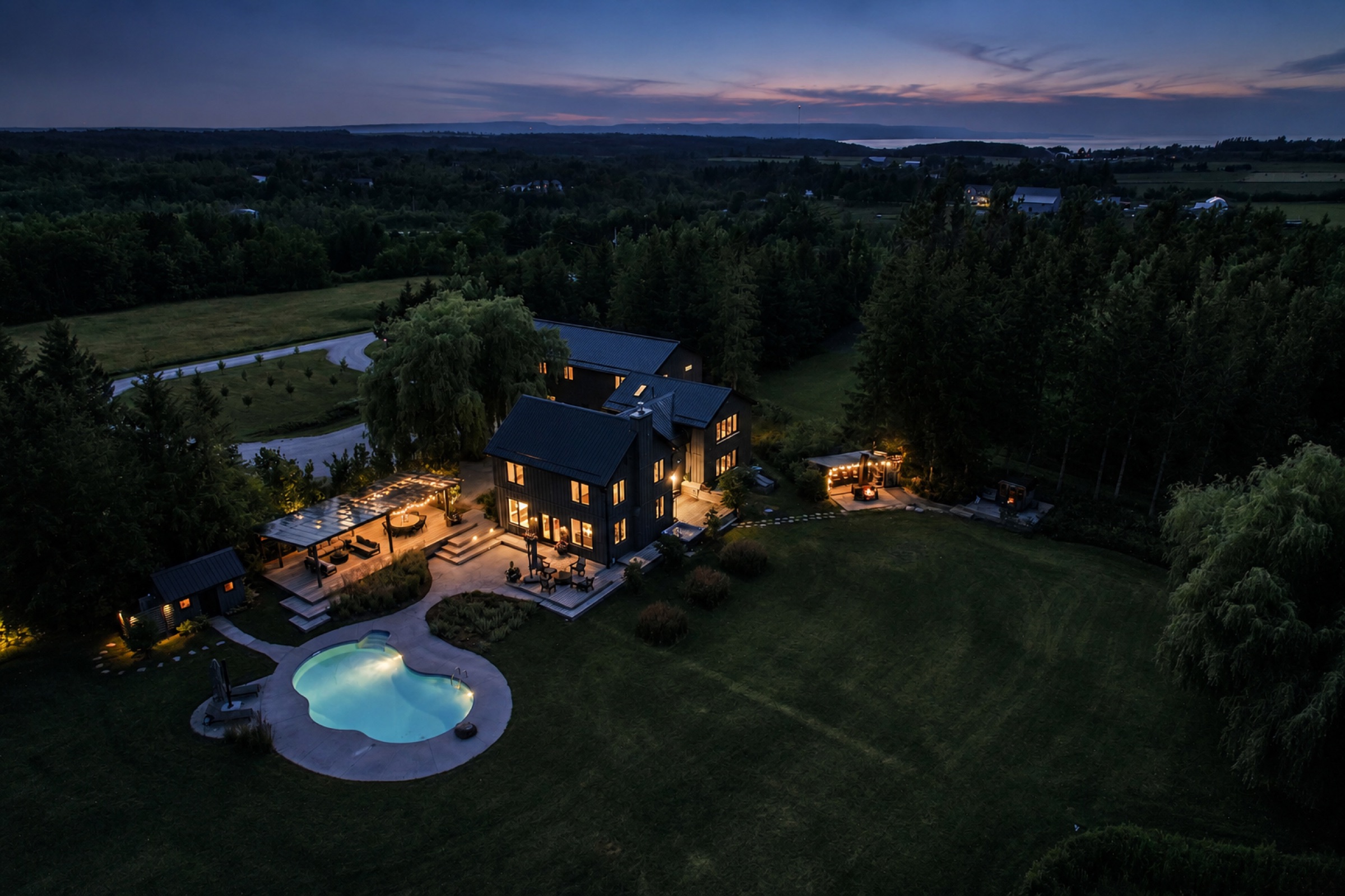 Aerial twilight view of the estate, pool, and Georgian Bay beyond
